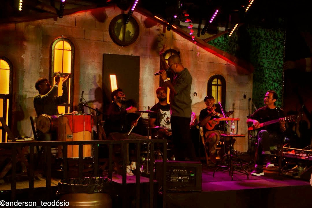 Banda no palco da Villa do Som sob iluminação roxa e cenografia da casa